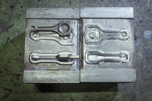 Fotografía de dos piezas de un molde industrial que utiliza SIE Cortes para fabricar piezas.