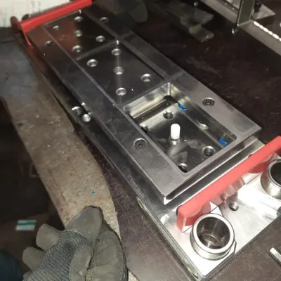 Fotografía a mano de un hombre de SIE Cortes utilizando un molde industrial para fabricar piezas